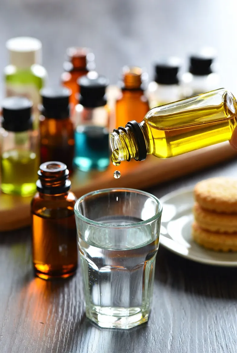 بطری اسانس خوراکی مرکبات روی میز چوبی – تصویر کلوزآپ